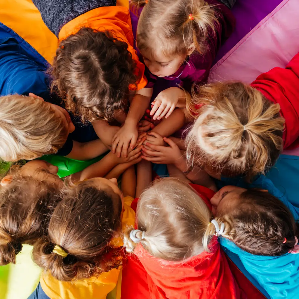 8 enfants réunis en cercle au sol, dans une de nos crèches hospitalières