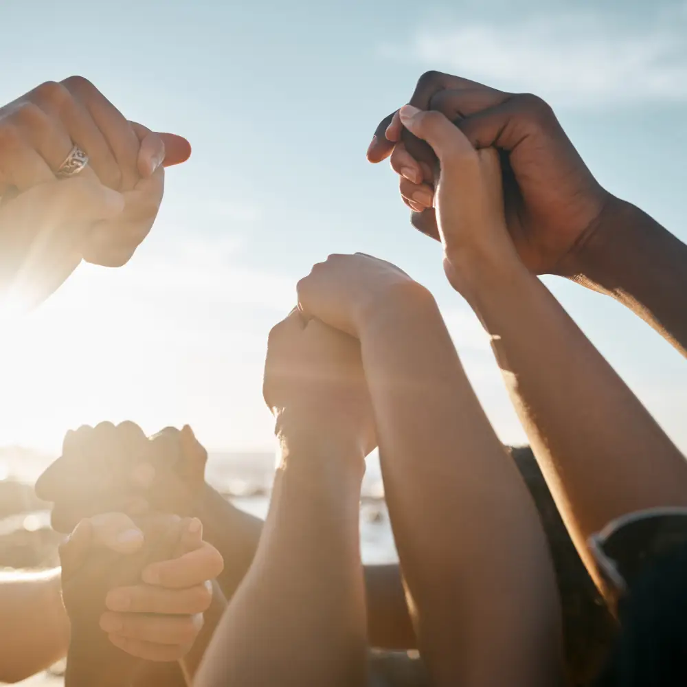 Un équipe se tenant les mains, et les levant au ciel de contentement
